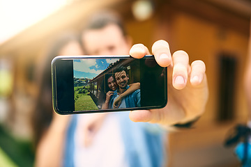 Image showing Happy couple, hug and phone screen for selfie, photo or profile picture together in relationship outdoors. Hand of man holding smartphone with woman hugging for love, memory or capture outside home