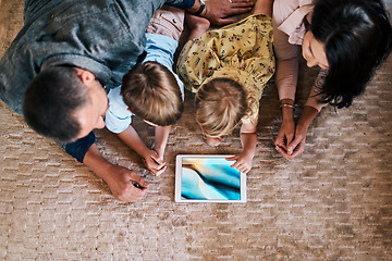 Image showing Tablet, screen and family streaming online content or social media on the internet and bonding in a home floor. Relax, mother and top view of father with children or kids in the living room using app