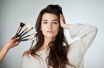 Image showing Makeup brush, face and beauty of a woman in studio with a natural glow. Portrait of a female model person on a grey background and hands for cosmetology transformation, powder cosmetics and skin care