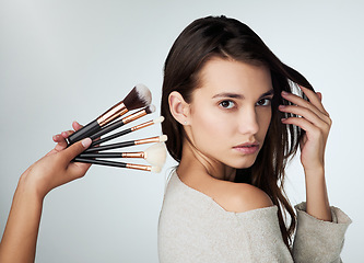 Image showing Beauty, makeup brush and face of a woman in studio with a natural glow. Portrait of a female person on a grey background with a hand for cosmetology tools, powder cosmetics and facial skin care