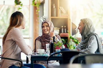 Image showing Friends, funny and Muslim women in cafe, bonding and talking together. Coffee shop, happy and Islamic girls, group or people laughing, conversation and discussion for social gathering in restaurant.