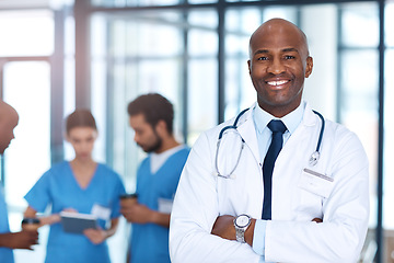 Image showing Leader, man and portrait of doctor in hospital, healthcare or clinic with medical expert nurses to trust in quality care. Black man, medicine and happy neurosurgeon with arms crossed in confidence