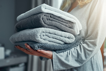 Image showing Laundry, cleaning and a woman with a pile of towels in her home for hygiene or a spring clean day. Hospitality, service and a female cleaner carrying a stack of fresh or clean fabric in a hotel room