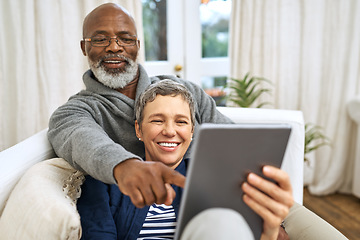 Image showing Technology, senior couple with tablet and on sofa happy in living room of their home. Social media or streaming, retirement or relax and happy married people on couch laughing with digital device