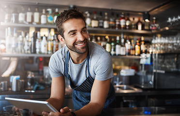 Image showing Smile, thinking and a barista with a tablet at a cafe for online orders and communication. Happy, ideas and a male pub manager or bartender with technology for an app, connection and ordering stock