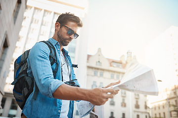 Image showing Tourist, man and a map in a city for travel on a street with a backpack for location or direction. Male person with paper for navigation outdoor on urban road for adventure, journey or vacation