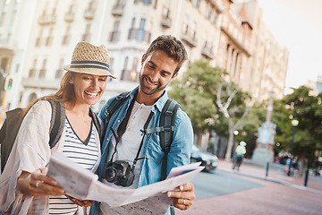 Image showing Tourist, couple and a map in a city for travel and search for street, location or direction. Man and a woman reading a paper for navigation outdoor on urban road for adventure, journey or vacation