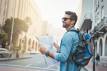 Image showing Man, tourist and a map in a city for travel on a street with a backpack for location or direction. Male person with paper for navigation outdoor on urban road for adventure, journey or vacation