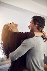 Image showing Laughing couple, love and hug in apartment for care, quality time and bonding together for commitment to relationship. Happy young man, woman and hugging for romance, smile and relax with joy at home