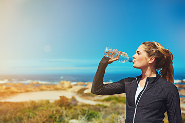 Image showing Woman drink water, beach and fitness with blue sky, athlete outdoor with hydration and mockup space. Exercise by the sea, female person drinking h2o from bottle with workout and break from training