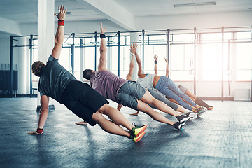 Image showing Fitness, group class and athletes doing a exercise in the gym for health, wellness and flexibility. Sports, training and people doing side plank exercise challenge together in sport studio or center.