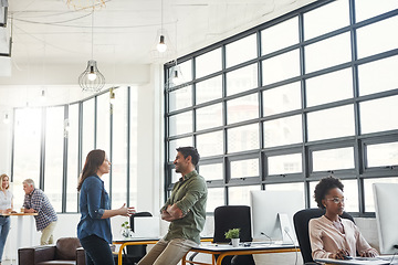 Image showing Conversation, man and woman in modern office with smile and creative advice at startup agency together. Talking, desk and happy team leader coaching designer at work with help, support and opinion.