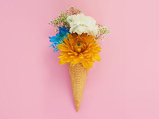 Image showing Flowers, cone and ice cream in a studio for decoration, creativity or art with fresh and colorful bouquet. Creative, still life and blossom floral plants in a dessert isolated by pink background.