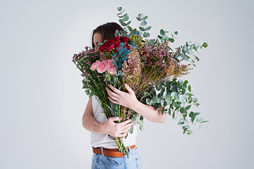 Image showing Nature, hide face and woman with flowers, bouquet or present against a grey background. Female person, model or girl with a floral present, creative aesthetics or natural products with sustainability