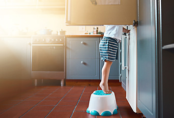 Image showing Small, looking and a child on a step for refrigerator food, breakfast or a snack in a house. Kitchen, morning and a little kid standing on a chair to look for a meal or lunch in the fridge for hunger