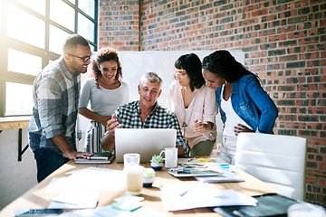 Image showing Diversity, group of colleagues and using a laptop together or collaborating on a new project and in a modern office. Teamwork, happy and businesspeople in a meeting or a conversation and work