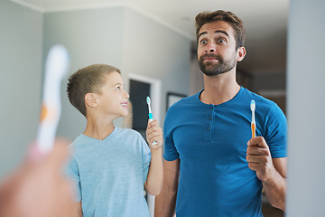 Image showing Funny face, brushing teeth and father with son in bathroom mirror for morning routine, comic and dental. Oral hygiene, cleaning and smile with man and child in family home for self care and wellness