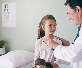 Image showing Healthcare, kids and a girl at a man pediatrician for an appointment or checkup in the hospital. Medical, stethoscope and heart with an adorable little female child sitting on a bed in the clinic