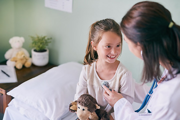 Image showing Healthcare, kids and a girl at a woman pediatrician for an appointment or checkup in the hospital. Medical, stethoscope and cardiology with an adorable female child sitting on a bed in the clinic