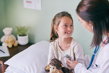 Image showing Medical, children and a girl at the pediatrician for an appointment or checkup in the hospital. Healthcare, stethoscope and cardiology with an adorable female child sitting on a bed in the clinic