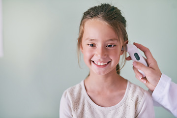 Image showing Healthcare, children and a girl at the pediatrician for a temperature checkup or appointment in the hospital. Medical, ear and thermometer with an adorable female child sitting in a health clinic