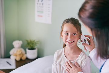 Image showing Healthcare, kids and a girl at the pediatrician for an ear exam, appointment or checkup in the hospital. Medical, happy and temperature with an adorable female child sitting on a bed in the clinic