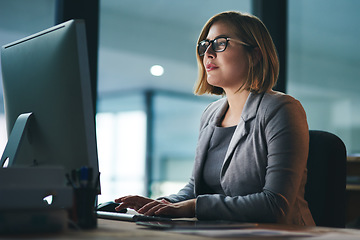 Image showing Computer, typing and business woman in office working late on project at night alone. Desktop, professional and female person writing email, report or planning, reading and overtime for deadline.