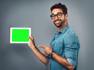 Image showing Happy man, tablet and pointing to green screen for advertising against a grey studio background. Portrait of male person showing technology display, chromakey or mockup for copy space advertisement