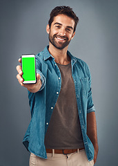 Image showing Happy man, phone and mockup green screen for advertising or marketing against a grey studio background. Portrait of male person smiling and showing smartphone display or chromakey for advertisement