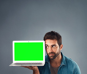 Image showing Man, laptop and thinking on mockup green screen for advertising or marketing against a grey studio background. Thoughtful male person showing computer display, mock up or copy space for advertisement