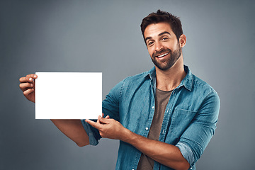 Image showing Happy man, billboard and mockup for advertising, marketing or branding against a grey studio background. Portrait of male person holding rectangle poster, placard or board of empty sign for message