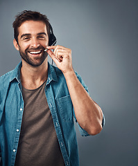 Image showing Happy man, call center and headphones of consultant on mockup against a grey studio background. Portrait of friendly male consulting agent smiling with headset mic in contact us for online advice