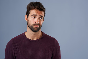 Image showing Doubt, thinking and face of man with unsure, uncertain and thoughtful on gray background in studio. Wonder mockup, advertising space and isolated male person worry for decision, choice and question