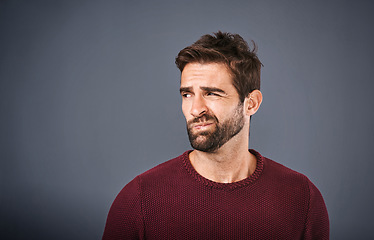 Image showing Doubt, thinking and face of unsure man in studio with worry, uncertain and thoughtful on gray background. Confused, mockup space and isolated male person skeptical for decision, choice and question