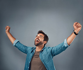 Image showing Happy man, fist and celebration for winning, success or achievement against a grey studio background. Male person screaming in victory, win or accomplishment in motivation for goals on mockup space