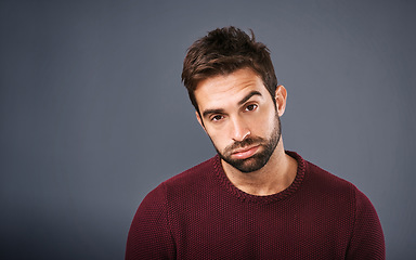 Image showing Bored, portrait and annoyed man in studio unhappy and moody against a grey background space. Sad face of depression and man with negative attitude posing with isolated, whatever or tired expression