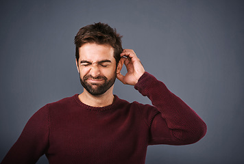 Image showing Worry, thinking and face of unsure man in studio with doubt, uncertain and thoughtful on gray background. Confused, mockup space and male person scratch head skeptical for decision, choice and idea