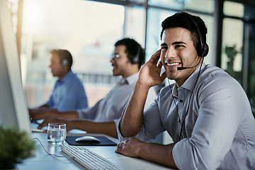 Image showing Callcenter agent, smile and man in office consulting with advice, help and happiness at desk. Happy phone call, conversation and service, customer support consultant speaking on headset at crm agency