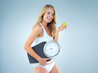 Image showing Woman in portrait, smile with apple and scale, lose weight and healthy food isolated on studio background. Female model, health and diet with organic fruit, mockup space and happiness with weightloss