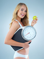 Image showing Happy woman in portrait, apple and scale, lose weight and healthy food isolated on studio background. Female model with smile, health and diet with organic fruit with happiness and weightloss