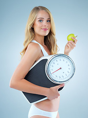 Image showing Woman in portrait, apple with scale and lose weight, smile with healthy food isolated on studio background. Happy female model, health and diet with organic fruit with nutrition and weightloss