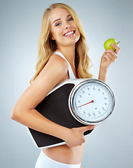 Image showing Woman in portrait, happy with apple and scale, lose weight and healthy food isolated on studio background. Female model with smile, health and diet with organic fruit with happiness and weightloss