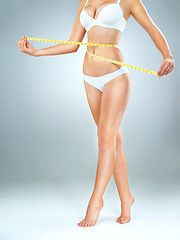 Image showing Woman in underwear, body and measuring tape, lose weight and fitness with abdomen isolated on studio background. Female person, waist measurement and diet with health, weightloss and exercise