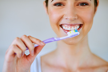 Image showing Toothpaste, toothbrush and woman brushing teeth in bathroom for health, happiness and wellness in morning. Girl, portrait and cleaning mouth or healthcare, dental care or oral hygiene, smile or home