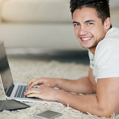 Image showing Laptop, blogging and portrait of man typing as remote work in his home, house or apartment with smile on the floor. Carpet, happy and young male person or freelancer working on project online or web