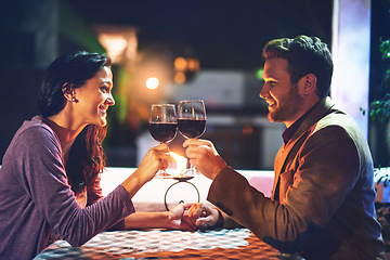 Image showing Cheers, wine and couple on date in restaurant, romance and happiness in celebration of love and drinks. Romantic honeymoon night, man and woman toast glasses in cafe, smile on dinner holiday travel.