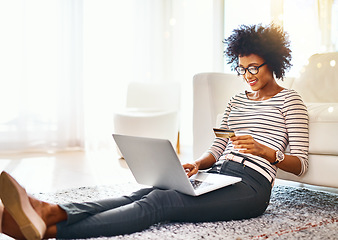 Image showing Woman, laptop and credit card on living room house doing online shopping sitting on ground. Home, bokeh mockup and computer of African female person buying on a ecommerce app reading online deal