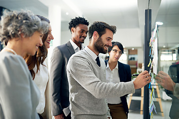 Image showing Business people, planning or happy man writing on board for brainstorming or speaking of solution or team ideas. Group goals, sticky note or group meeting with leadership for problem solving together