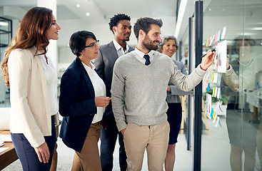 Image showing Business people, brainstorming or man writing on board for planning or speaking of solution or team ideas. Group goal, sticky note or employees in meeting with leadership for problem solving together