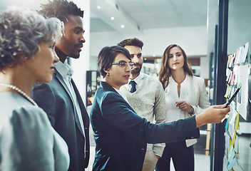 Image showing Business people, teamwork or woman writing on board for brainstorming or speaking of solution, ideas or goals. Group planning, sticky note or group with leadership for project collaboration together